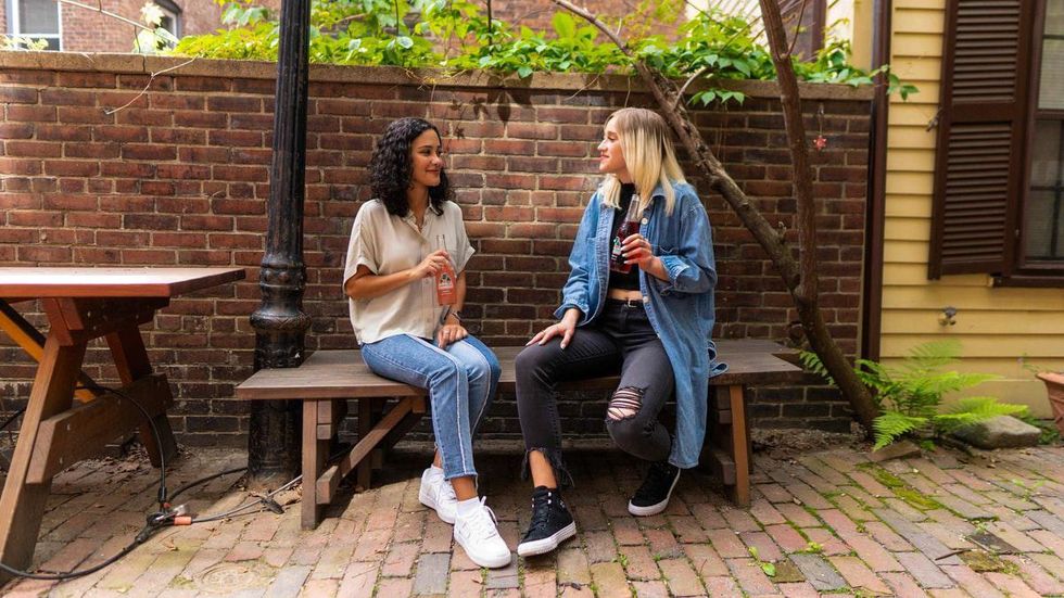 two women talking on a bench