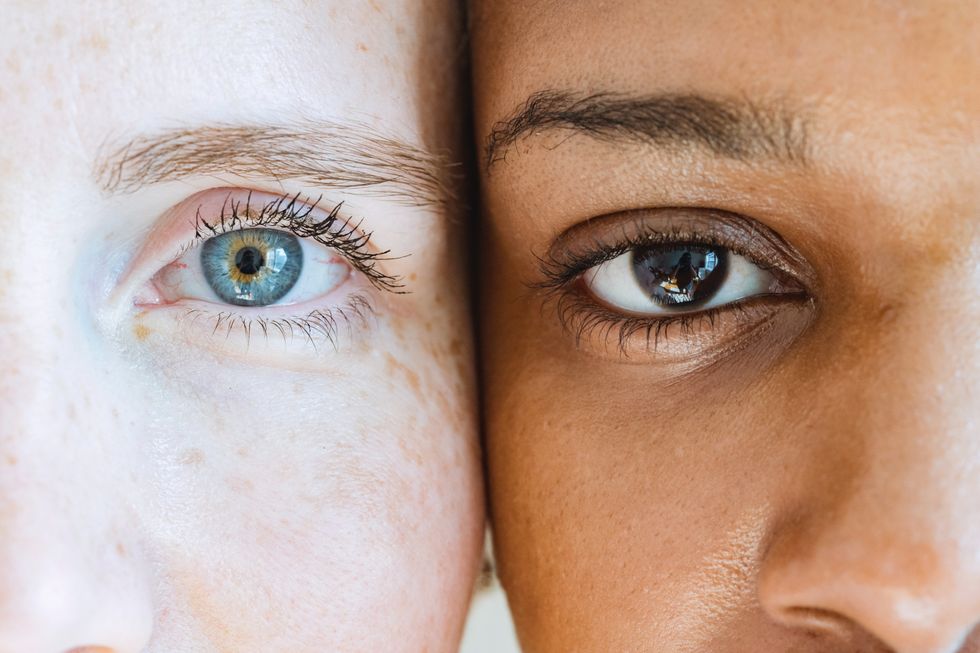 two women with different skin tones looking at camera with colored eyes