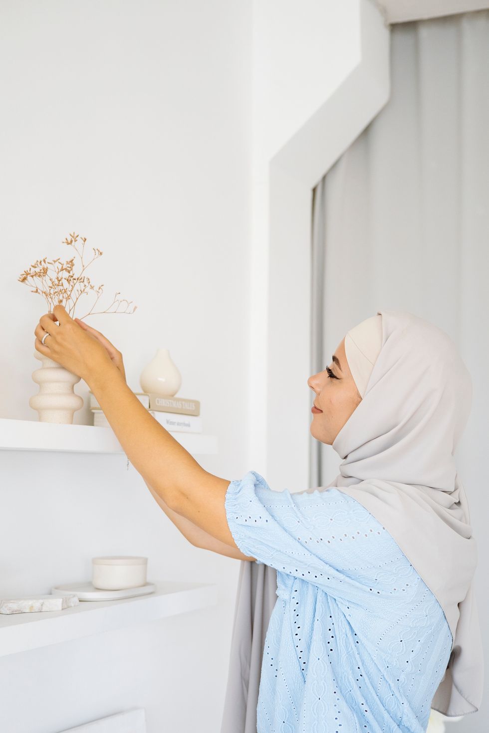 woman decorating with vase and flowers