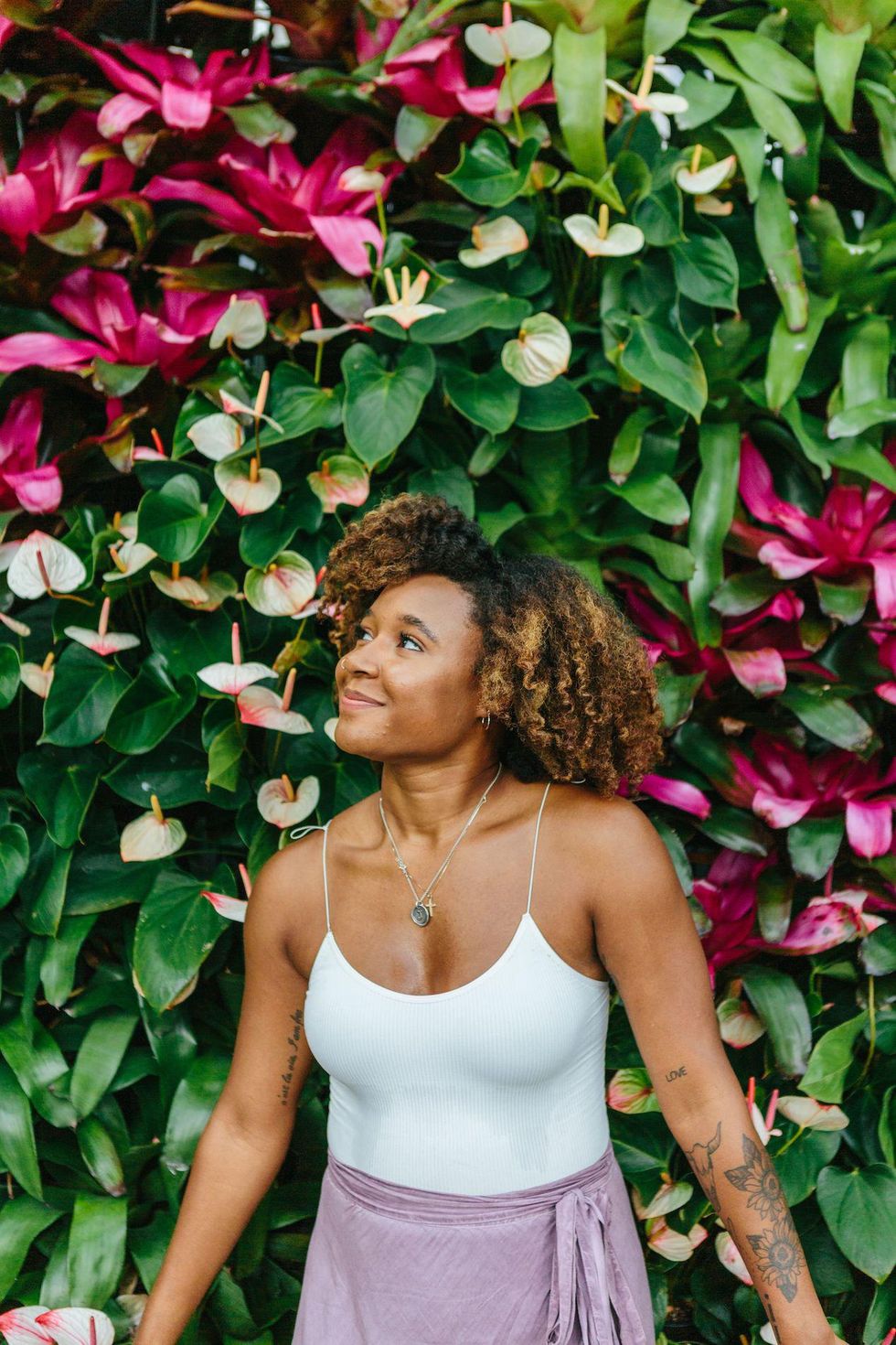 woman enjoying nature in front of plant wall