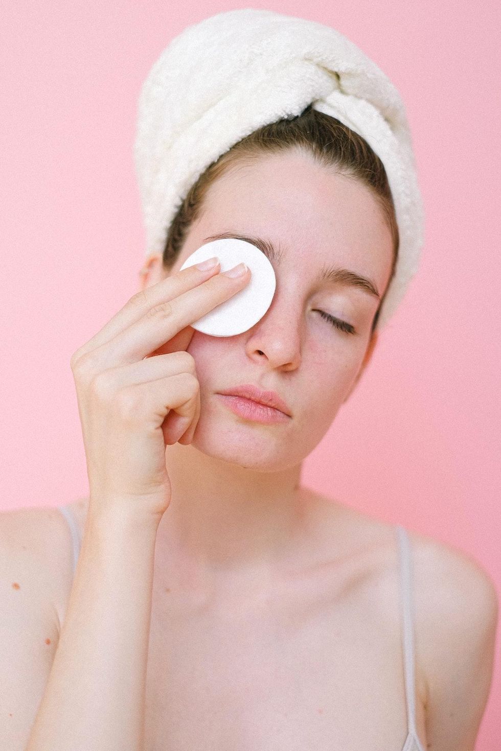 woman gently removing her eye makeup