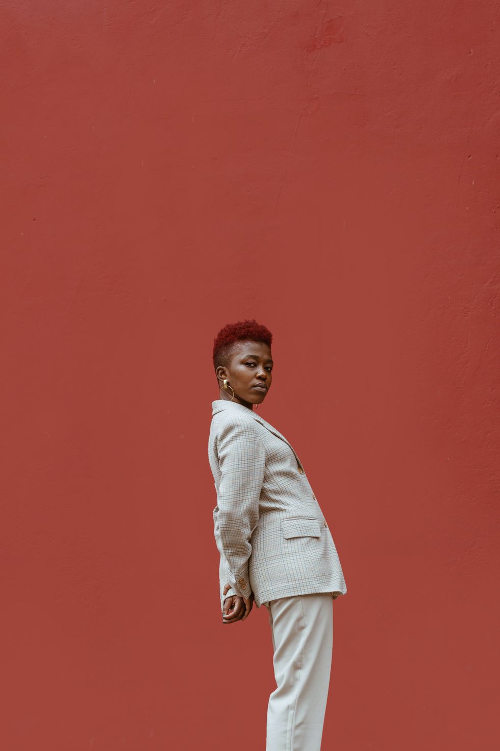 woman in a suit set posing against a red background