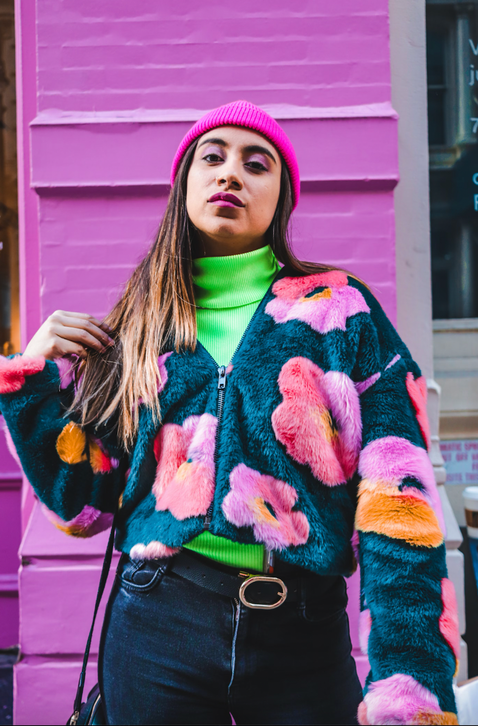 woman in floral jacket in front of a purple wall