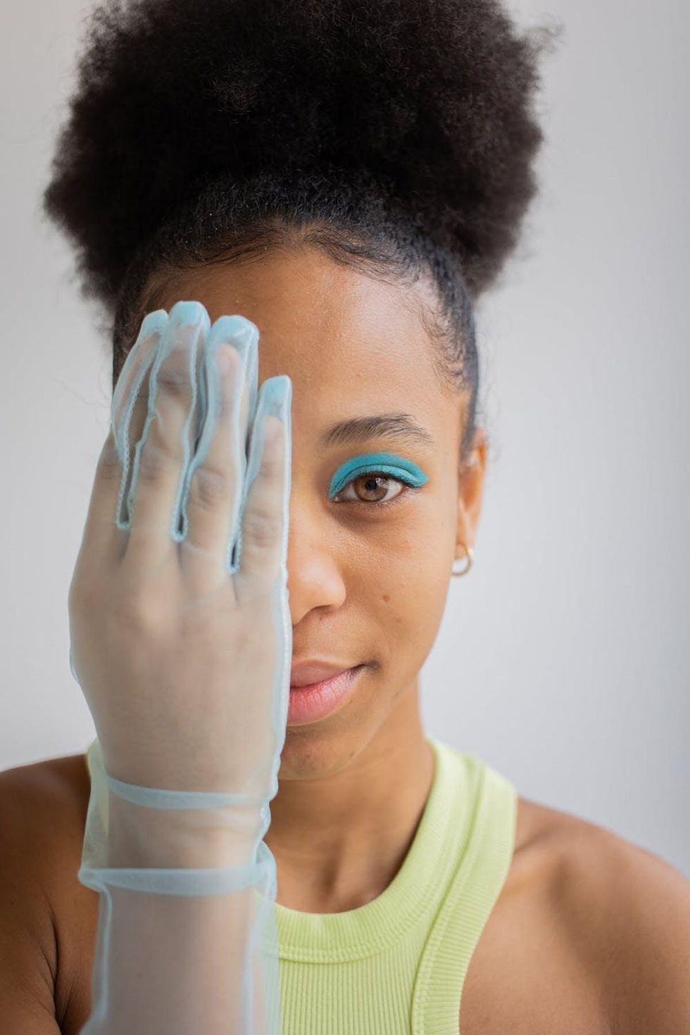 woman in green tank top with teal eye shadow