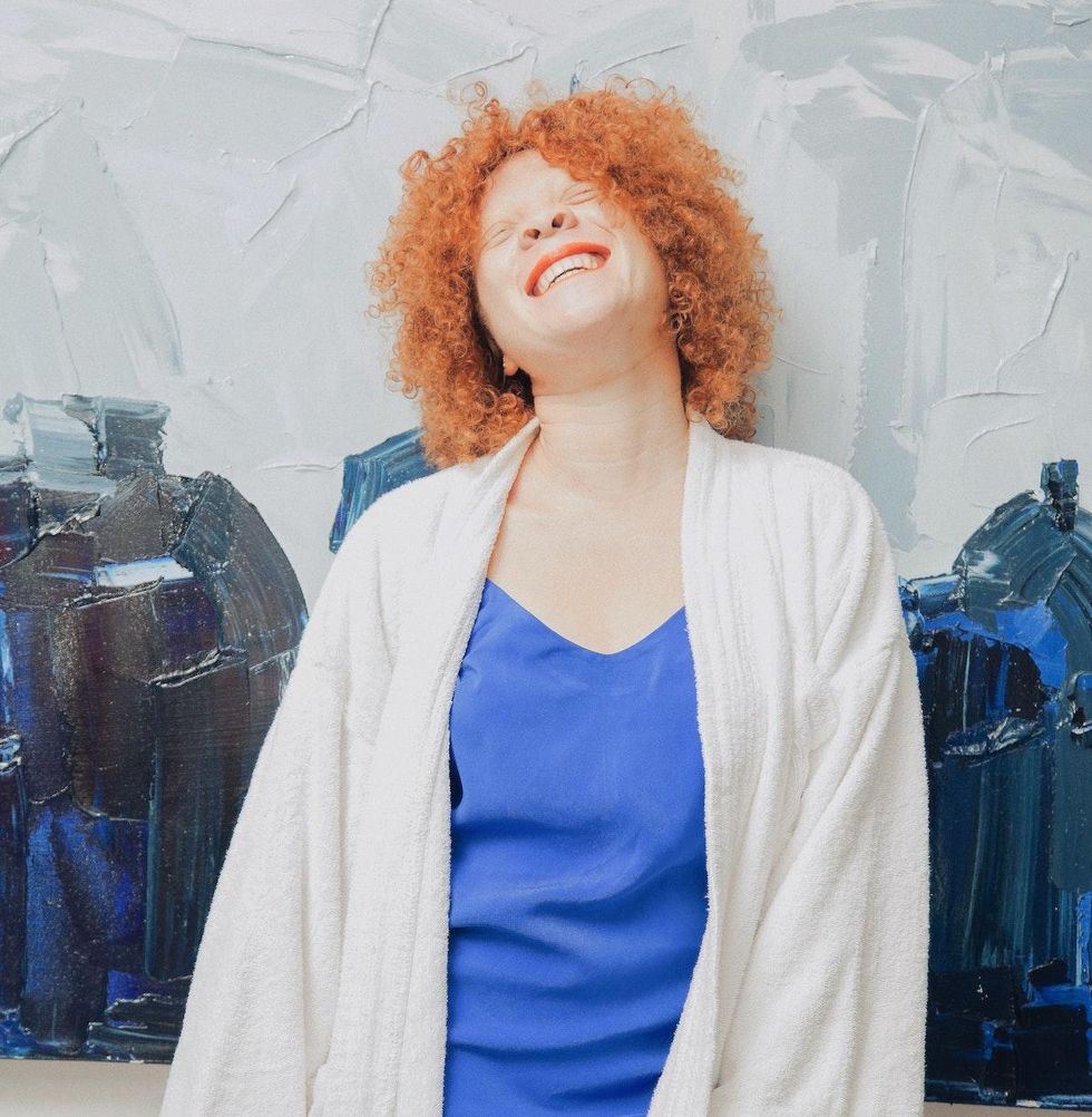 woman laughing and smiling against blue background