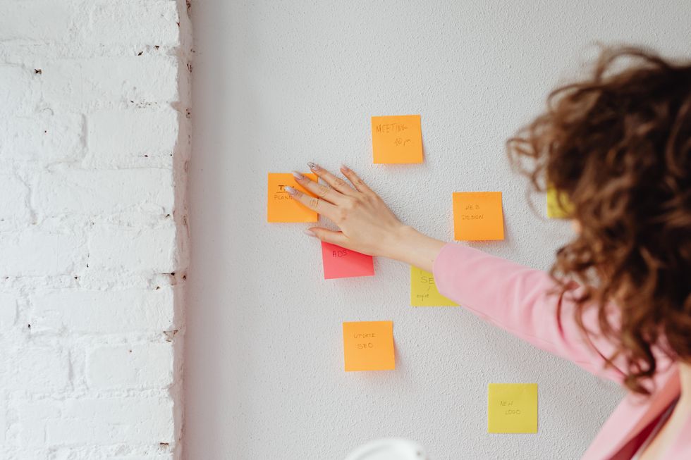 woman looking at post-it notes, making decisions