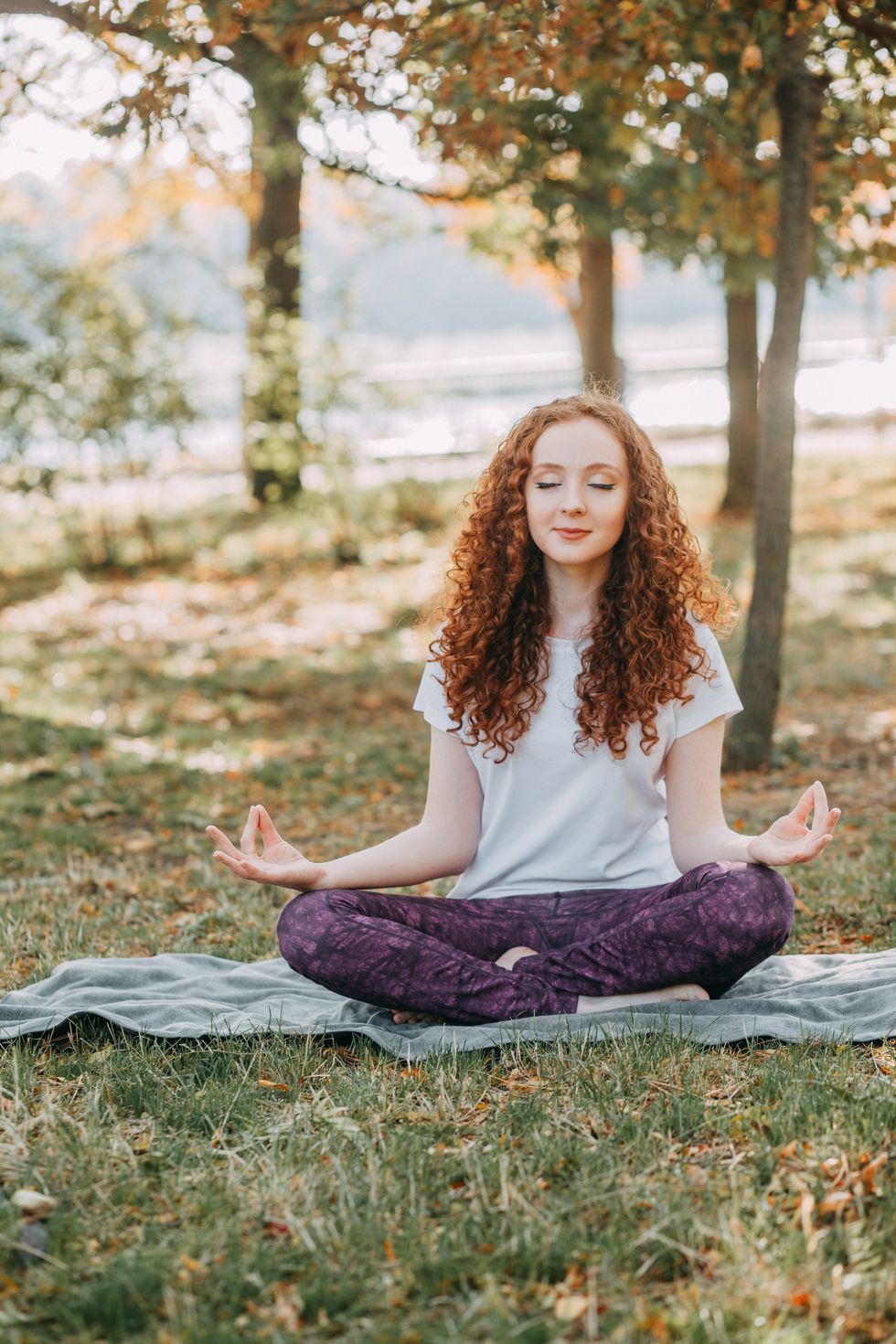 woman meditating in the grass