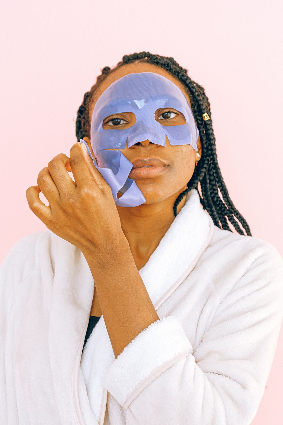 woman peeling purple face mask off