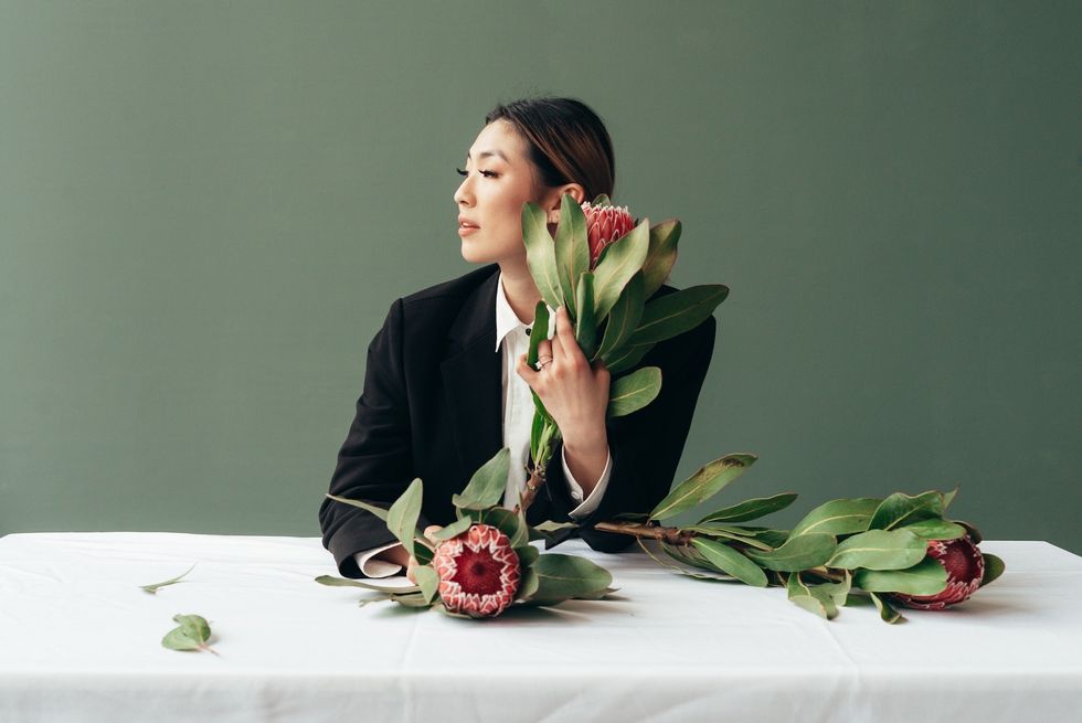 woman sitting at a table with flowers