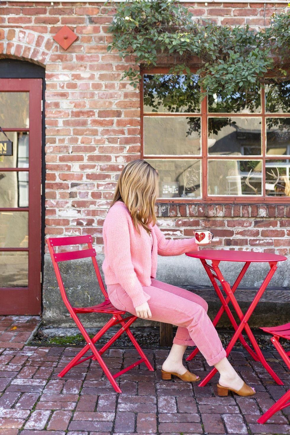 woman sitting at a table with her coffee