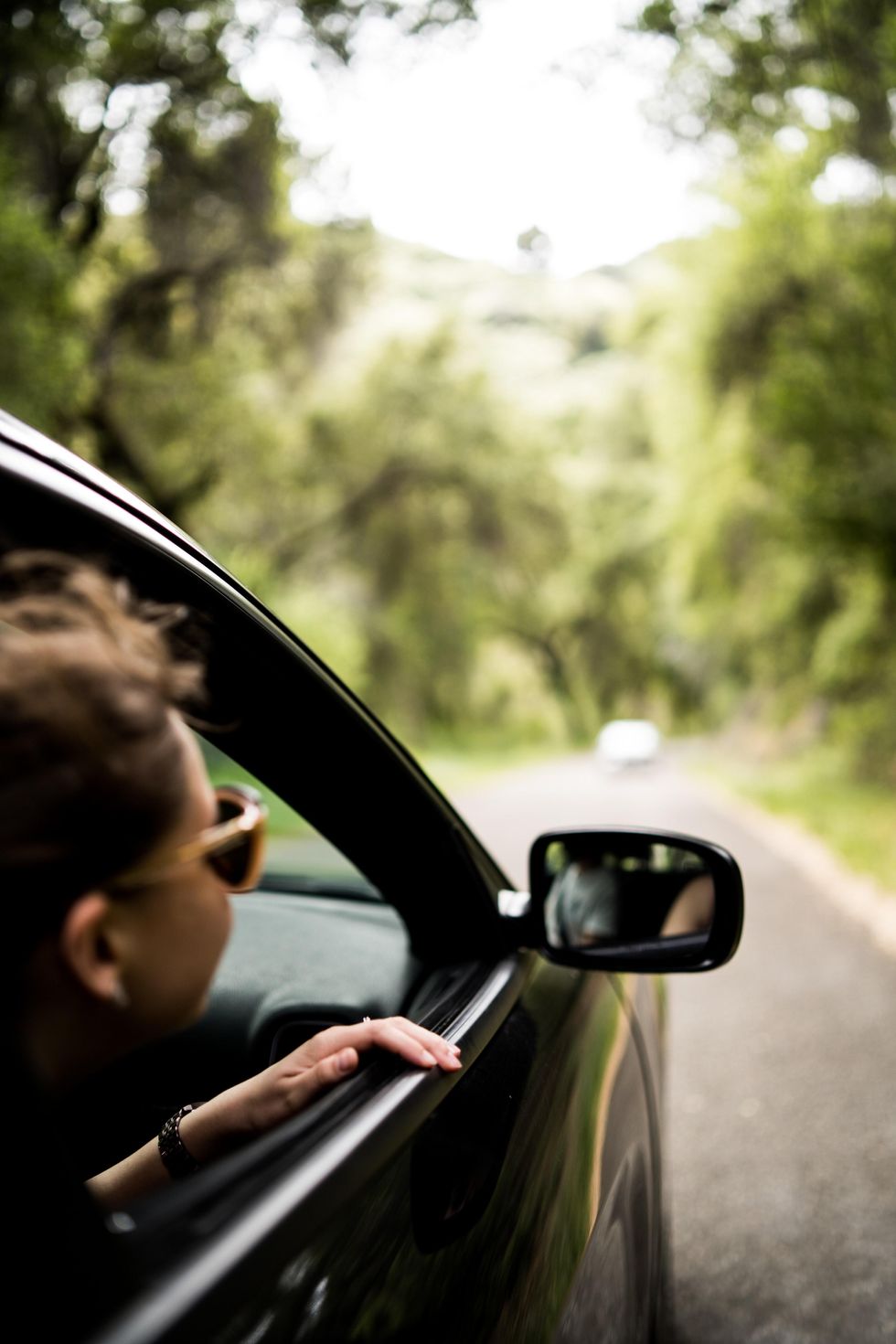 woman sitting in her car looking out her window