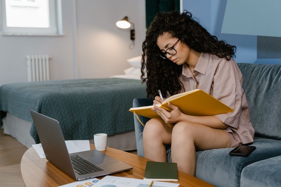 woman sitting on the couch journaling