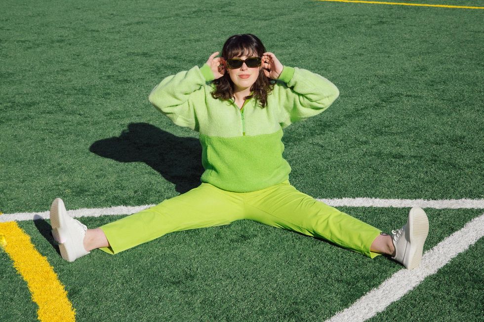 woman stretching in green workout clothes