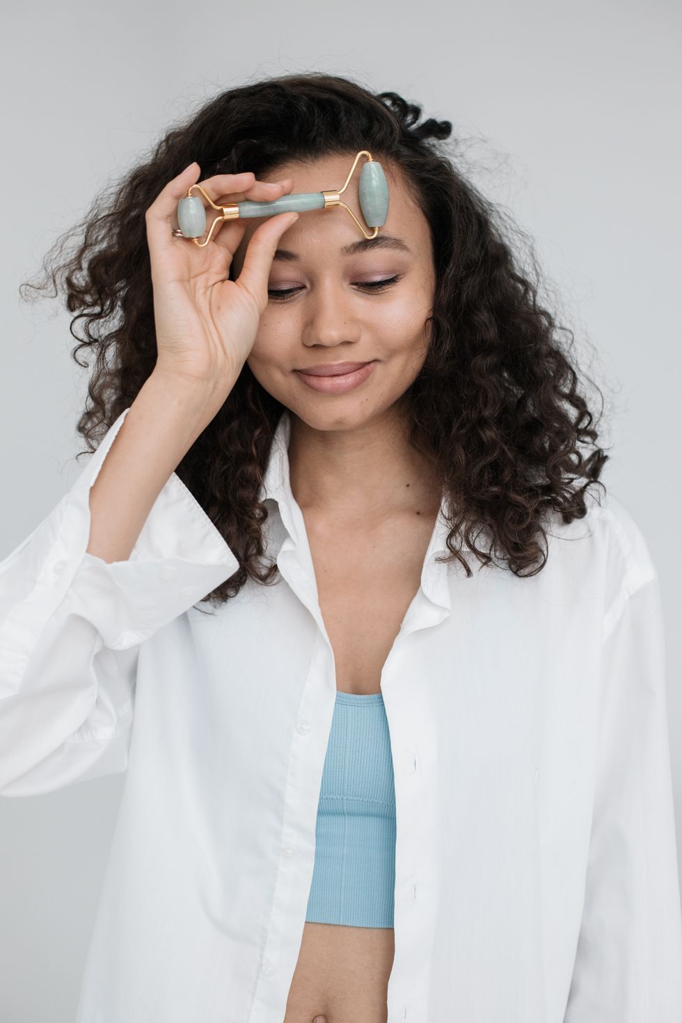 woman using face roller for lymphatic massage