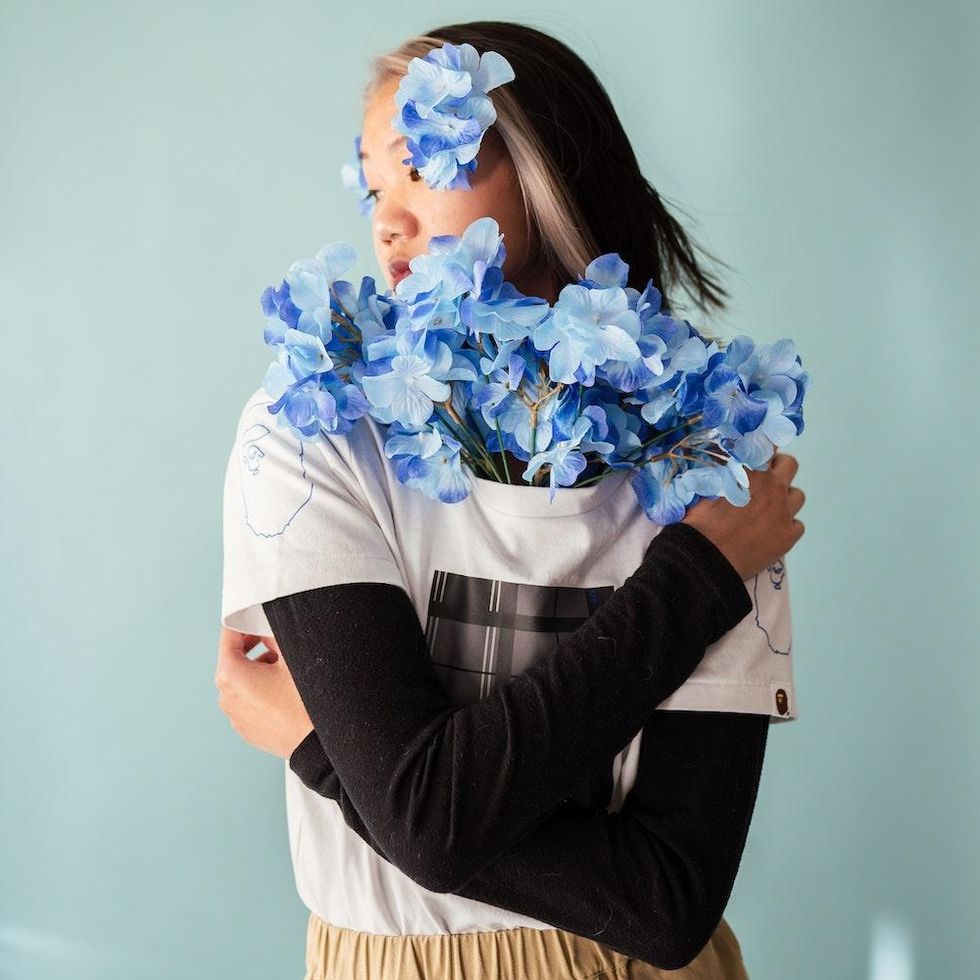 woman with blue flowers sticking out of her shirt