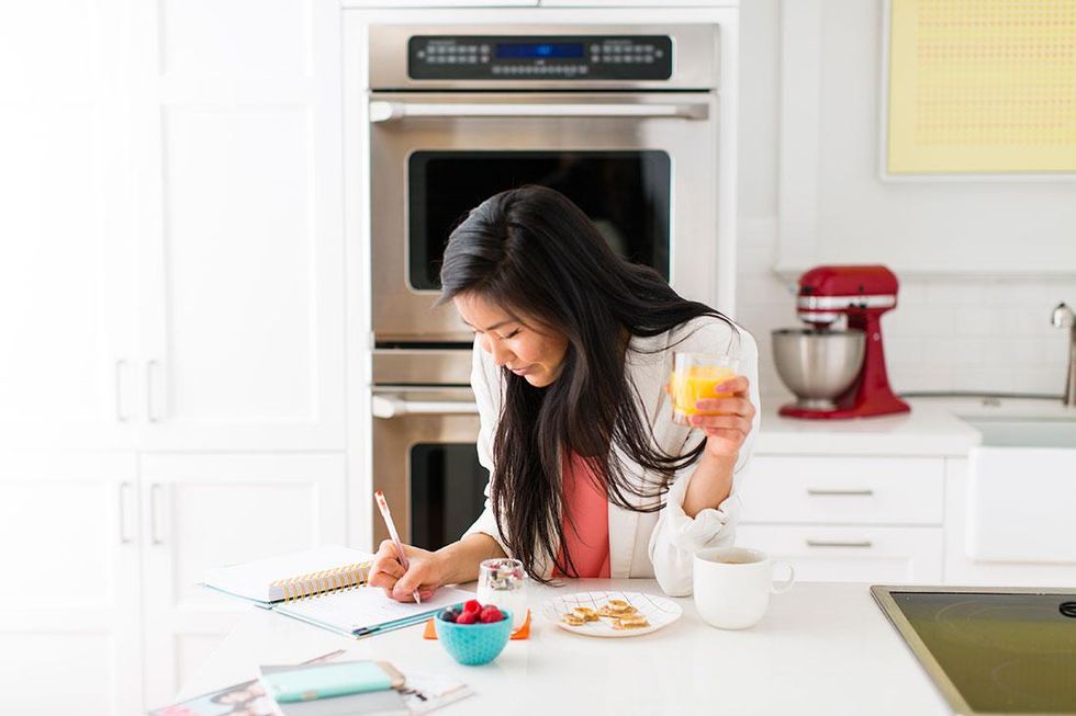 woman writing at breakfast journaling