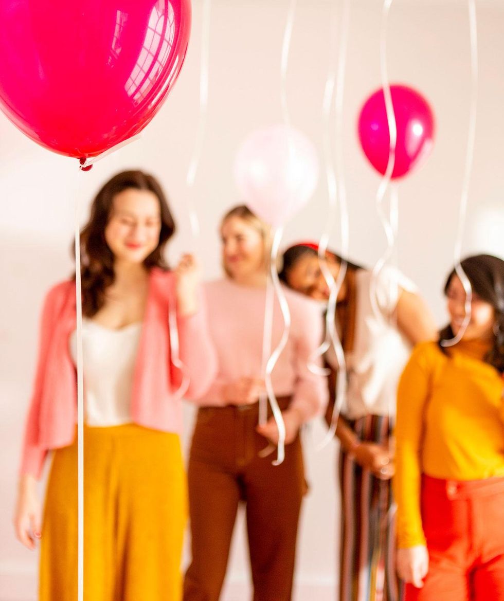 women hanging out together behind balloons